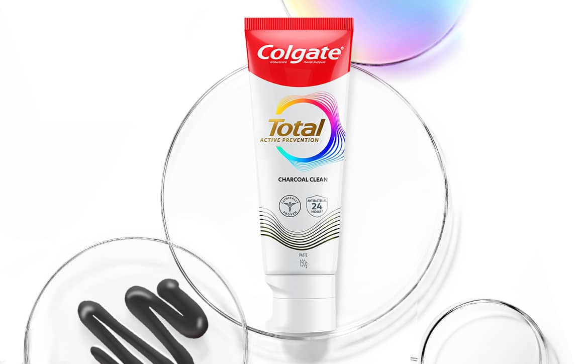 Tabung pasta gigi Total Charcoal dengan piring Petri dan gelembung spektrum di belakangnya
