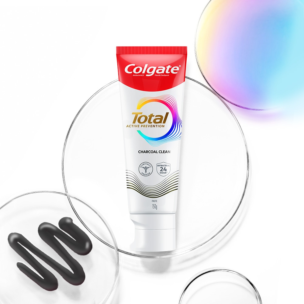 Tabung pasta gigi Colgate Total di latar depan, dengan gelembung transparan dan spektrum di latar belakang