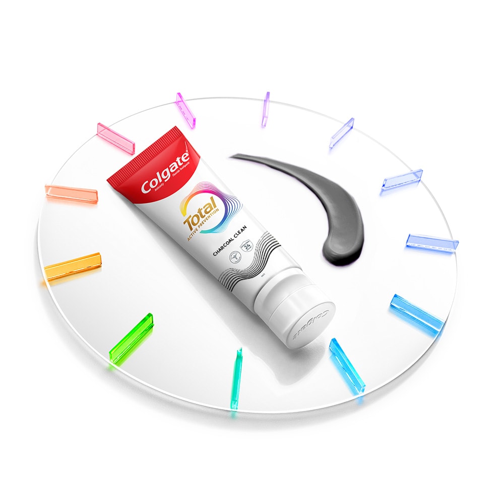 Tabung pasta gigi Colgate Total di atas jam dengan pasta di sebelahnyaTabung pasta gigi Colgate Total di atas jam dengan pasta di sebelahnya