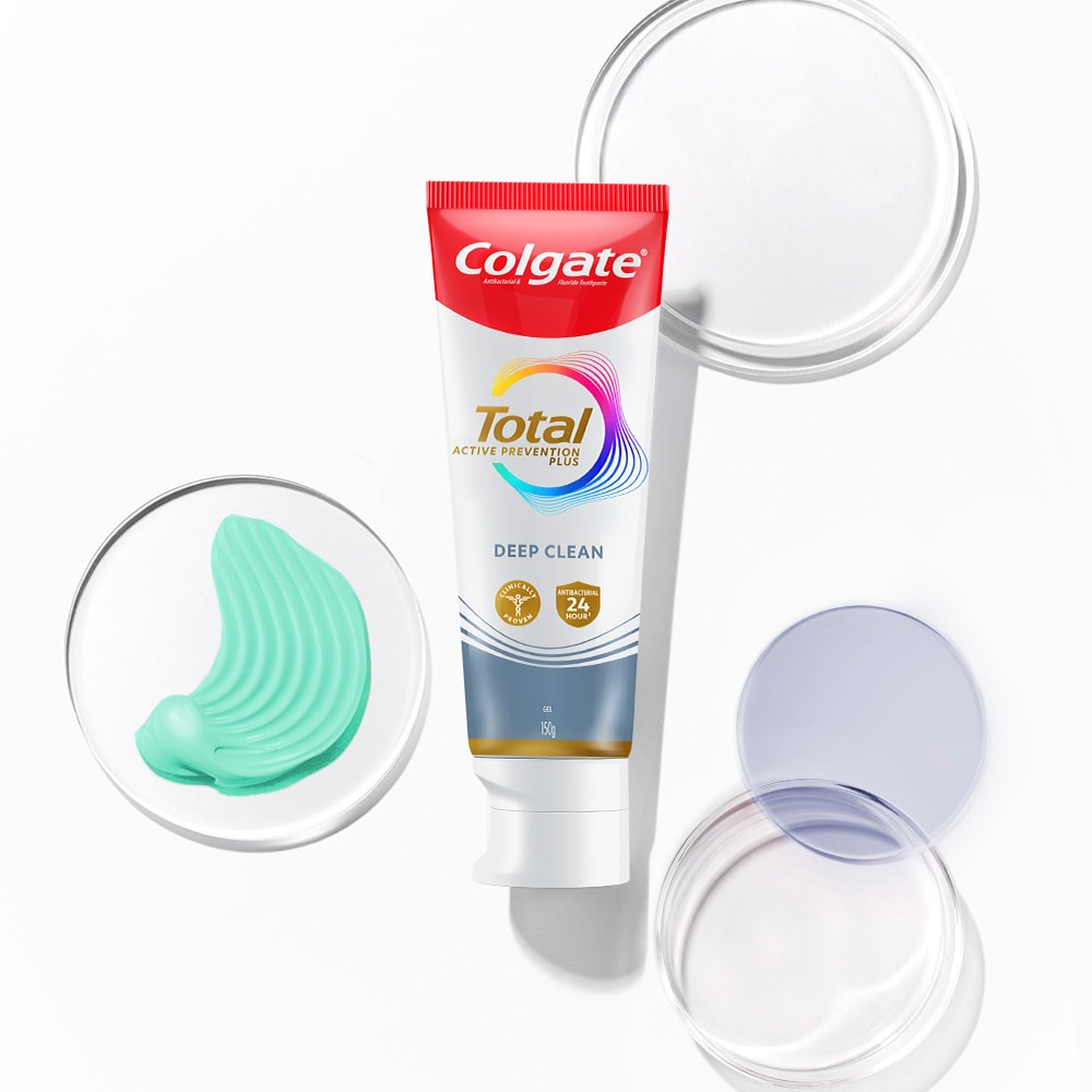 Tabung pasta gigi Colgate Total di latar depan, dengan gelembung transparan dan spektrum di latar belakang