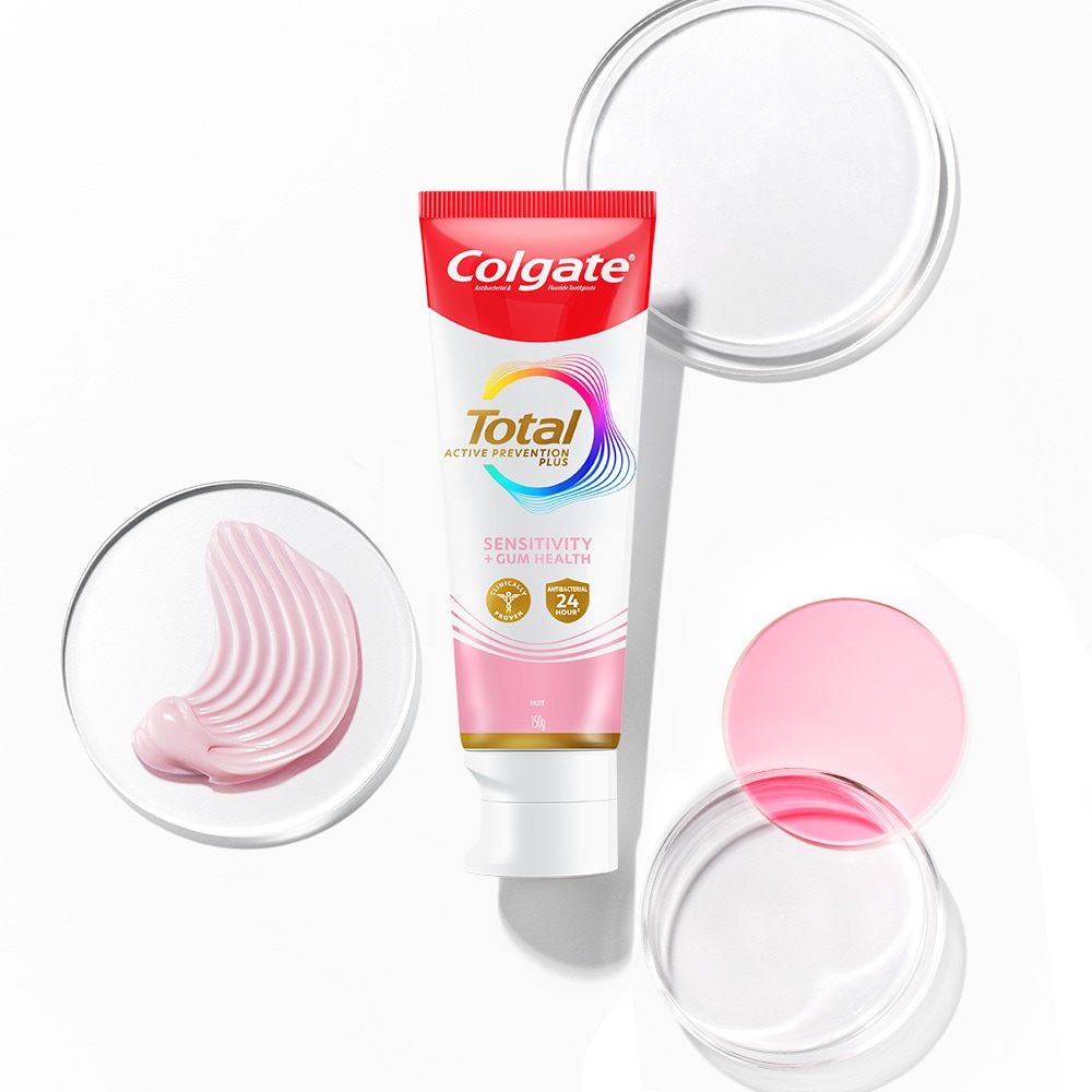 Tabung pasta gigi Colgate Total di latar depan, dengan gelembung transparan dan spektrum di latar belakang